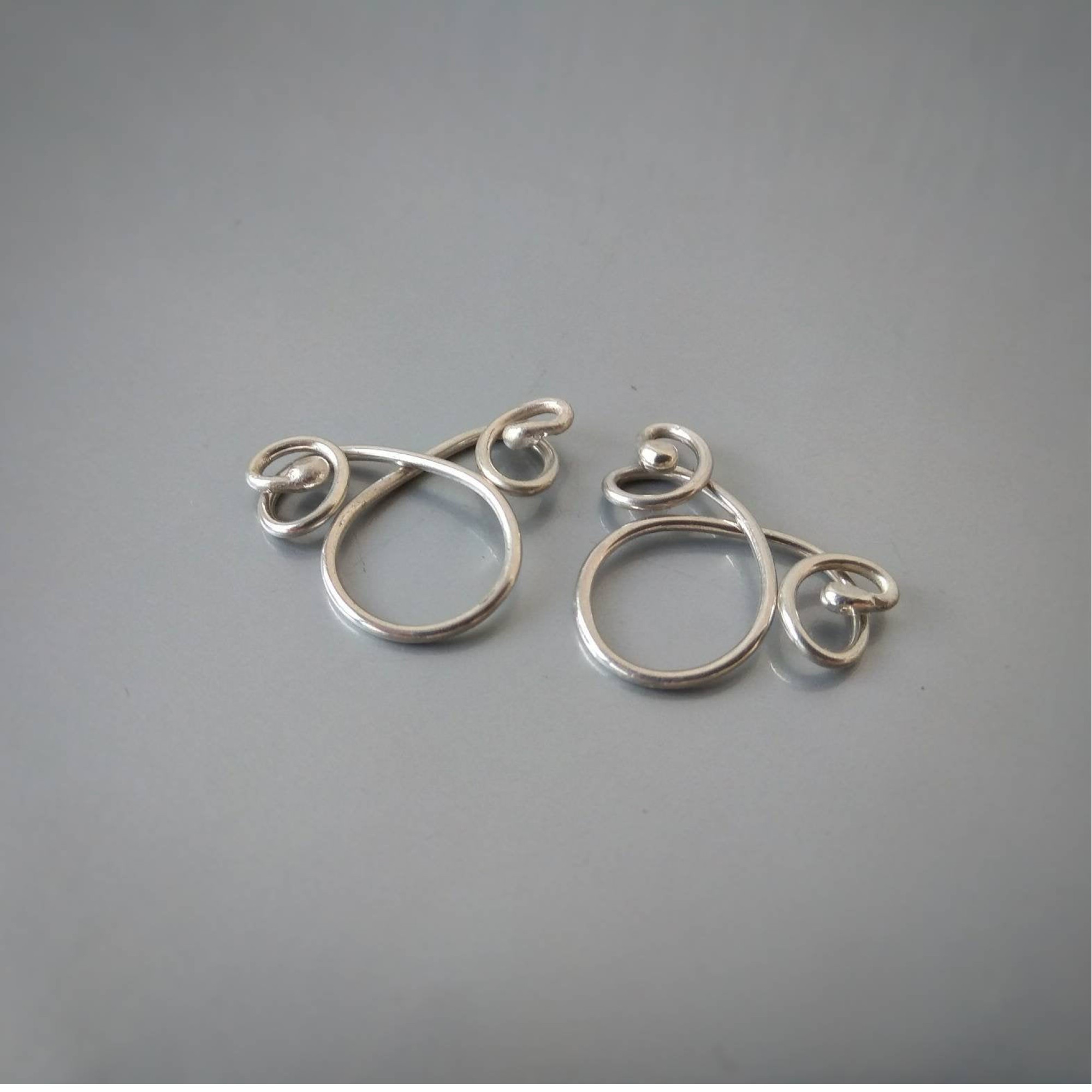 Handmade silver non-piercing nipple rings with elegant loop and swirl design. Adjustable fit, comfortable wear, sold as a matching pair — Image 1 of 6